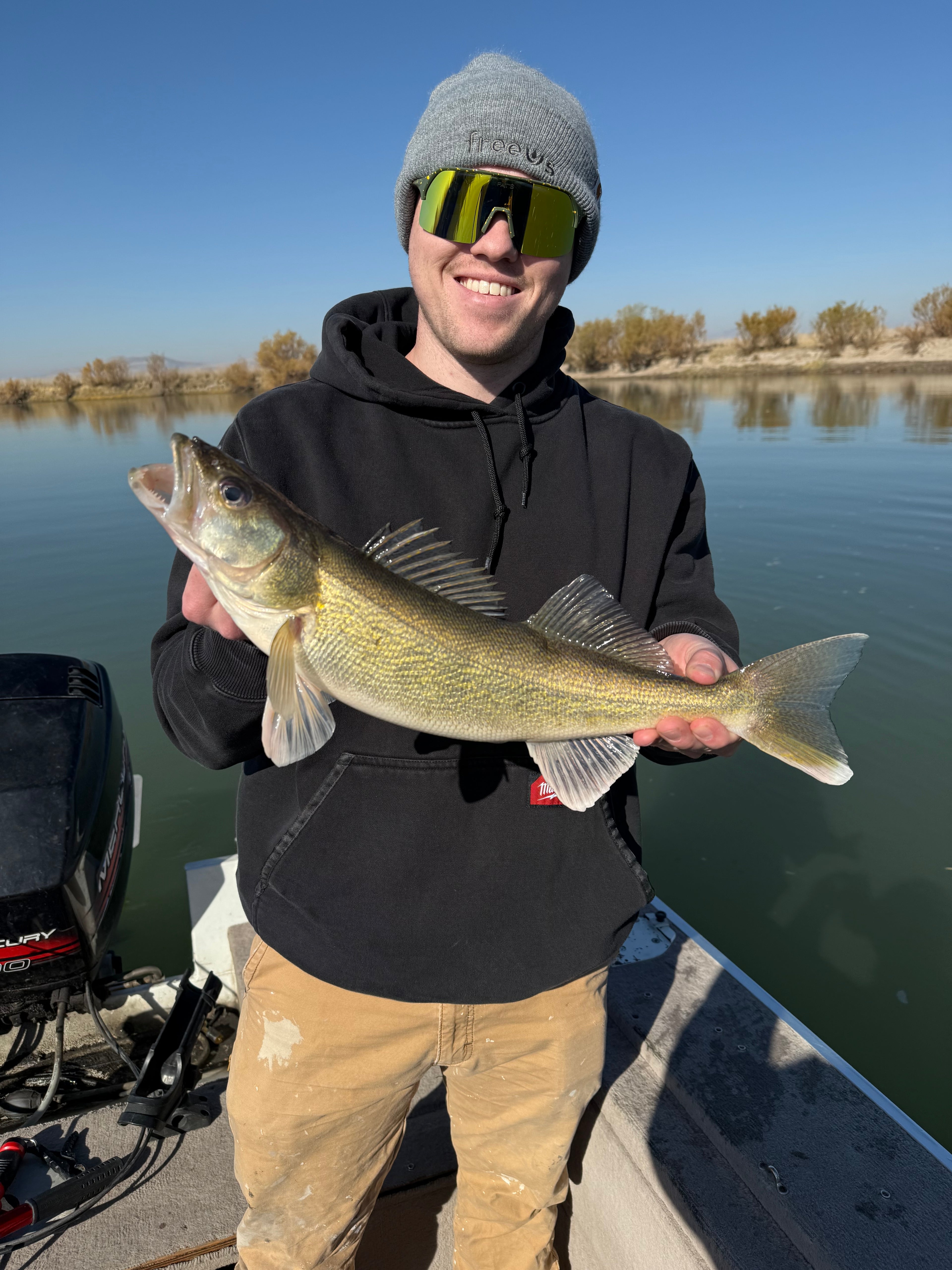 Man with large fish wearing Fat's Brook Trout Sunglasses